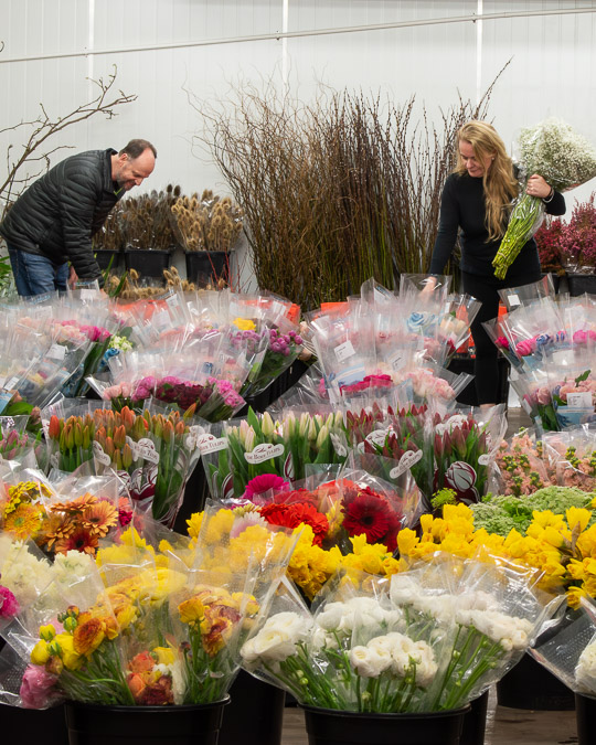 Tom and Carolyne, the founders, are examining flowers at their beloved flower market, Flowers WA -Perth.